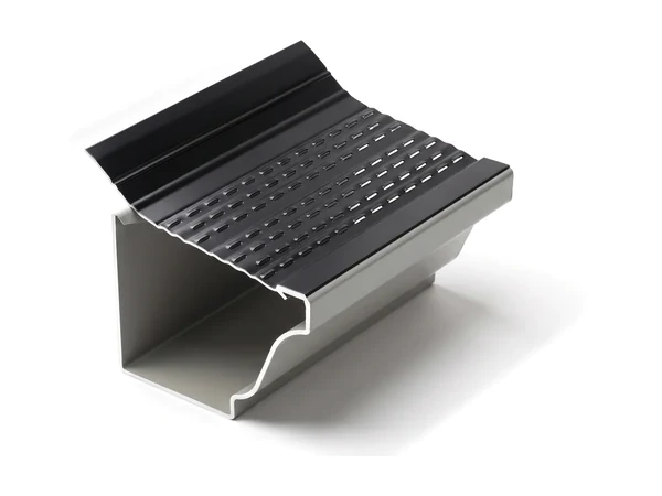 A louvered gutter guard on a grey K-style gutter: a black aluminum cover with rows of small louvers, sloping up from the gutter’s lip