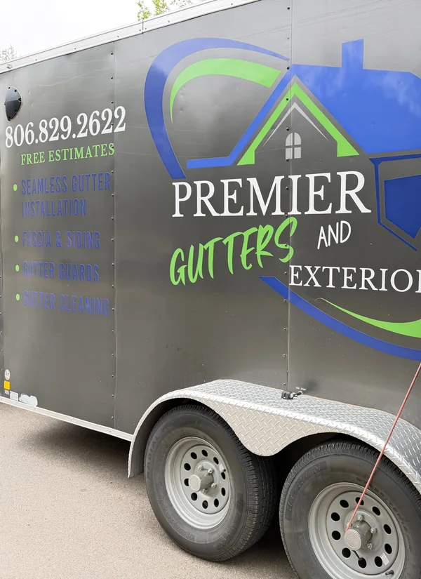 The Premier Gutters and Exterior trailer with its phone number, 806.829.2622, and its logo