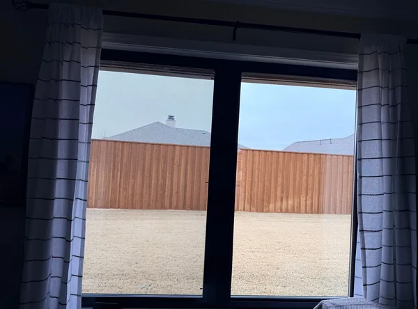 A new black double window seen from inside, between two curtains