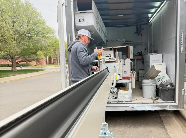 A Premier crew member forming a seamless gutter in the trailer