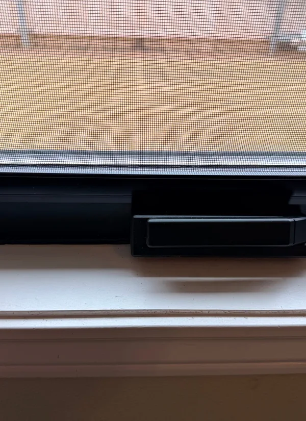 A new black window frame and its lock, up close